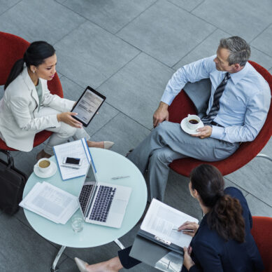 High angle view of businesspeople discussing strategy at coffee table in office